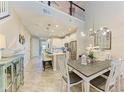 Open concept dining and living area featuring modern chandelier, tile floors and access to the kitchen at 11607 Meadowgate Pl, Bradenton, FL 34211