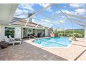 Relaxing screened pool area with brick pavers, hot tub, and lush landscaping at 1730 Hudson St, Englewood, FL 34223