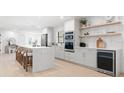 Contemporary kitchen featuring white cabinets, a wine fridge, and stylish open shelving at 2846 Pheasant Run, Clearwater, FL 33759