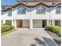 The townhome showcases a neat exterior with a two-car garage and landscaped grounds at 285 Madeira Cir, Tierra Verde, FL 33715