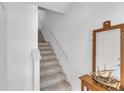Bright staircase with carpeted steps, white walls, and a small table with decor at 285 Madeira Cir, Tierra Verde, FL 33715