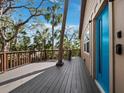 Exterior deck with wood railings, blue front door and tropical landscaping at 3376 S Seclusion Dr, Sarasota, FL 34239