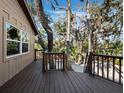Open deck with wood railing and staircase overlooking the yard's mature trees at 3376 S Seclusion Dr, Sarasota, FL 34239