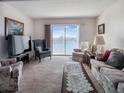 Cozy living room with comfortable seating, carpeted floors, and sliding glass doors that offer a view of the lake at 3424 Lake Bayshore Dr # 405, Bradenton, FL 34205