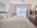 Comfortable main bedroom featuring dark wood furniture and a sliding glass door leading to a balcony with a lake view at 3424 Lake Bayshore Dr # 405, Bradenton, FL 34205