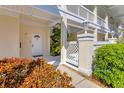 Condo entrance with white door and light fixtures framed by landscaping and privacy fence at 3701 54Th W Dr # 103, Bradenton, FL 34210