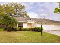 Well-kept villa featuring manicured lawn, a palm tree, an attached two-car garage, and a lamp post, offering a welcoming ambiance at 4018 Oakhurst Dr # 3181, Sarasota, FL 34233
