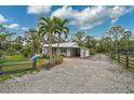 Charming single-story home with mature palm trees and a decorative fence enhancing its curb appeal at 4116 34Th E Ave, Bradenton, FL 34208