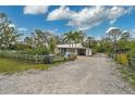 Charming home with a well-maintained front yard, a decorative fence, and a long gravel driveway at 4116 34Th E Ave, Bradenton, FL 34208