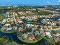 Aerial view of the property showcasing its location on a cul-de-sac surrounded by trees and water at 4173 Hearthstone Dr, Sarasota, FL 34238