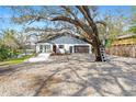 Lovely home featuring an oversized front lawn and a welcoming porch, set against a backdrop of mature trees at 4540 Murdock Ave, Sarasota, FL 34231