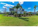 Beautiful two-story home with lush green lawn, elegant landscaping, and swaying palm trees at 4789 Vasca Dr, Sarasota, FL 34240