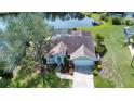 Aerial view of house with a screened in pool, pond and manicured lawn at 5110 76Th E St, Bradenton, FL 34203
