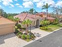 Beautiful home exterior with tile roof, arched entryway, and a brick paver driveway at 5142 Cote Du Rhone Way, Sarasota, FL 34238