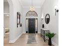 Elegant foyer featuring a black front door, pendant lighting, and stylish decor at 5142 Cote Du Rhone Way, Sarasota, FL 34238