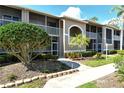 A beautiful exterior view of the condos showing screened lanais and mature landscaping at 5250 Hyland Hills Ave # 1514, Sarasota, FL 34241
