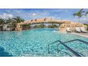 Beautiful in-ground pool with a stone archway and waterfall feature for luxurious swimming at 5517 Palmer Cir # 203, Bradenton, FL 34211