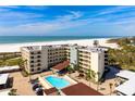 Condominium complex with a community pool, beach access, and well-maintained grounds at 5740 Midnight Pass Rd # 402, Sarasota, FL 34242