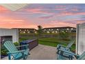 Relaxing back patio featuring green Adirondack chairs and a serene view of the water at 5778 Windy Bay Ter, Nokomis, FL 34275