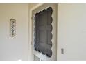 Close-up of the front door with decorative details and a unique screen door design at 5869 Tidewood Ave # 7, Sarasota, FL 34231
