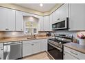 Well-lit kitchen showcasing white cabinets, stainless steel appliances, and a modern faucet, perfect for cooking and cleaning at 5869 Tidewood Ave # 7, Sarasota, FL 34231