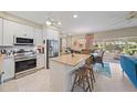 Bright kitchen features stainless appliances, a kitchen island with seating, and an adjacent dining area with ample natural light at 5869 Tidewood Ave # 7, Sarasota, FL 34231