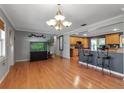 Open-concept living room with hardwood floors and a view into the kitchen with a breakfast bar at 605 15Th Avenue E Dr, Palmetto, FL 34221