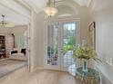 Bright foyer featuring tile floors, arched doorway, glass french doors and a decorative table with a vase of flowers at 7432 Ascot Ct, University Park, FL 34201
