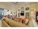 Comfortable living room featuring built-in shelving and direct access to the lanai at 7762 Us Open Loop, Lakewood Ranch, FL 34202