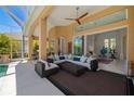 Covered outdoor patio featuring comfortable seating, a ceiling fan, and easy access to the pool and interior at 8122 Spring Marsh Dr, University Park, FL 34201