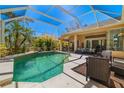Relaxing screened-in pool area with ample seating, lush tropical landscaping, and a bright blue sky overhead at 8122 Spring Marsh Dr, University Park, FL 34201