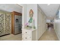 Inviting hallway featuring storage closets, a view of the kitchen, and tile floors at 8735 Midnight Pass Rd # 105B, Sarasota, FL 34242