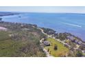 Breathtaking aerial view of the waterfront property featuring manicured grounds and mature trees at 92 Tidy Island Blvd, Bradenton, FL 34210