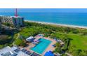 Beautiful view of community pool, sun loungers, tropical landscaping, and beachfront condos at 1055 Gulf Of Mexico Dr # 405, Longboat Key, FL 34228