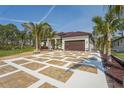 Well landscaped single Gathering home with palm trees and a stylish decorative driveway at 115 Solana St, North Port, FL 34287
