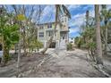 Charming two-story home with a light green exterior, white trim and beautiful tropical landscaping at 123 Faubel St, Sarasota, FL 34242