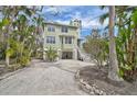 Charming two-story home with a light green exterior, white trim and beautiful tropical landscaping at 123 Faubel St, Sarasota, FL 34242