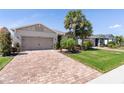 Attractive home with a brick driveway, well-kept lawn and landscaping under a bright blue sky at 14355 59Th E Cir, Bradenton, FL 34211