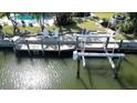 Waterfront home featuring a private dock with a boat lift, seating area, and easy access to the open water at 1633 Ridgewood Ln, Sarasota, FL 34231