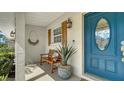 Inviting entryway featuring a blue door, wooden shutters, decorative lantern, and bench at 1633 Ridgewood Ln, Sarasota, FL 34231