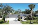 Charming single-story home featuring a beautifully landscaped yard, modern metal roof and paved driveway at 1633 Ridgewood Ln, Sarasota, FL 34231