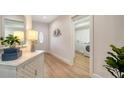 Bright hallway with wood floors, console table, and a laundry room visible nearby at 1633 Ridgewood Ln, Sarasota, FL 34231