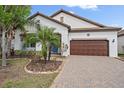 Beautiful home featuring a well-manicured lawn, a two-car garage, and a tile roof at 16810 Scuba Crest St, Wimauma, FL 33598