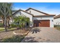 Charming home with a well-manicured front yard and a two-car garage on a brick driveway at 16810 Scuba Crest St, Wimauma, FL 33598