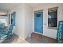 Inviting front porch with blue door, chairs, shutters, and welcome sign at 16810 Scuba Crest St, Wimauma, FL 33598