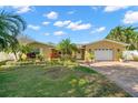Charming home boasts a manicured lawn, mature palms, brick driveway, and a two-car garage at 1940 35Th N St, St Petersburg, FL 33713