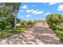 Beautiful home showcasing a brick driveway, lush landscaping, and well-maintained lawn at 1940 35Th N St, St Petersburg, FL 33713