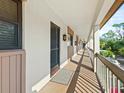 Condo hallway with exterior doors, outdoor lighting, and a view of trees, and the property grounds at 2526 Clubhouse Dr # 203, Sarasota, FL 34232