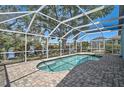 Inviting screened-in pool area with brick pavers, overlooking a serene lake at 5261 Highbury Cir, Sarasota, FL 34238