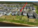 An aerial view showcasing a beautiful home with a spacious backyard, a lake, and a lush green landscape at 5675 Equator Ct, Nokomis, FL 34275